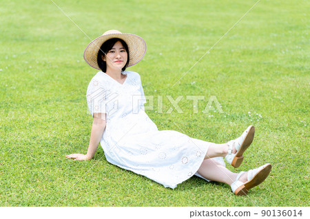 戴著草帽的女人在草坪上放鬆 戴著草帽的女人在草坪上放鬆 90136014