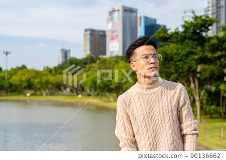 Portrait of handsome young man in park during summer Portrait of handsome young man in park during summer 90136662