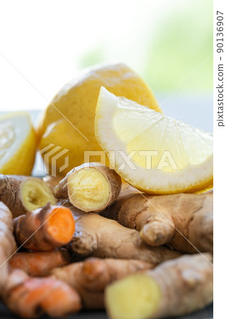 Roots of ginger and turmeric with lemon on plate Roots of ginger and turmeric with lemon on plate 90136907
