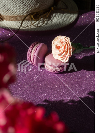 A set of two purple macaroons and a rose on the background of flowers, shiny purple background A set of two purple macaroons and a rose on the background of flowers, shiny purple background 90138153