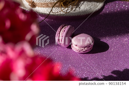 A set of two purple macaroons on the background of flowers, shiny purple background A set of two purple macaroons on the background of flowers, shiny purple background 90138154