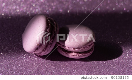 A set of two purple macaroons and a rose on sparkling purple background A set of two purple macaroons and a rose on sparkling purple background 90138155