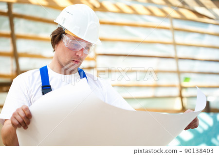 builder manager looking at the construction plan 90138403