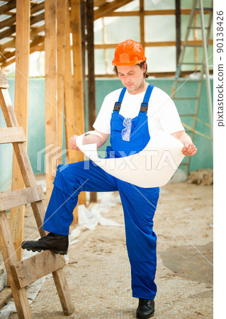 builder looking at the construction plan builder looking at the construction plan 90138426
