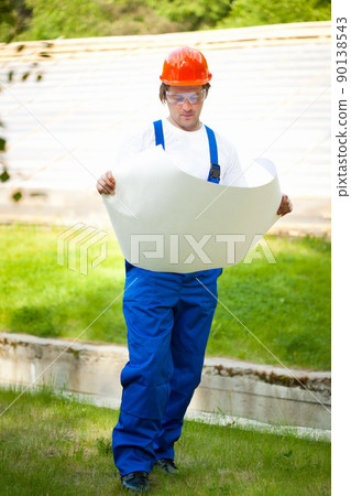 engeneer looking at the blueprint engeneer looking at the blueprint 90138543