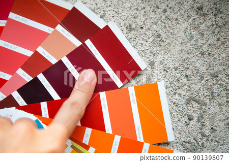 Selection of the paint color for decorative home repairs to the palette with layouts. A fan of shades in your hand inside the home. Repair and construction, paint and varnish coating 90139807