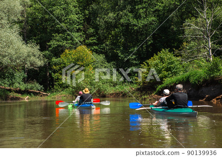 Family kayak trip. Man and woman and elderly couple senior and seniora rowing boat on the river, a water hike, a summer adventure. Eco-friendly and extreme tourism, active and healthy lifestyle 90139936