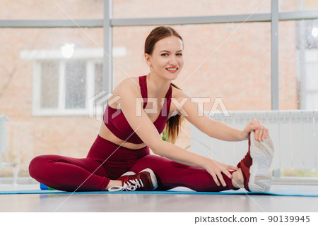 a girl in a tracksuit does exercises for muscle stretching and flexibility. 90139945