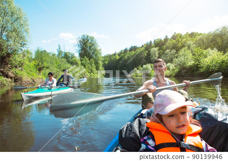 Family kayak trip. Father and daughter, and elderly couple senior and seniora rowing boat on the river, a water hike, a summer adventure. Eco-friendly and extreme tourism, active and healthy lifestyle Family kayak trip. Father and daughter, and elderly couple senior and seniora rowing boat on the river, a water hike, a summer adventure. Eco-friendly and extreme tourism, active and healthy lifestyle 90139946