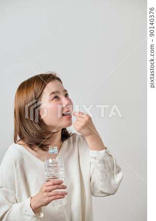 服用膠囊片的年輕女子 服用膠囊片的年輕女子 90140376