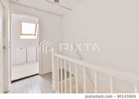 White door of room located near framed pictures and stylish lamp on top of stairway at home White door of room located near framed pictures and stylish lamp on top of stairway at home 90143669