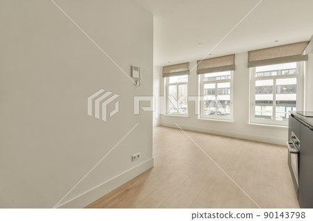 A spacious empty room in bright colors with large window in a cozy apartment 90143798