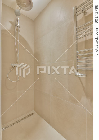Shower cabin lined with beige tiles in a cozy house 90143799