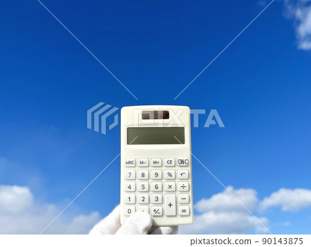 Hand with white gloves holding a calculator_blue sky background 90143875