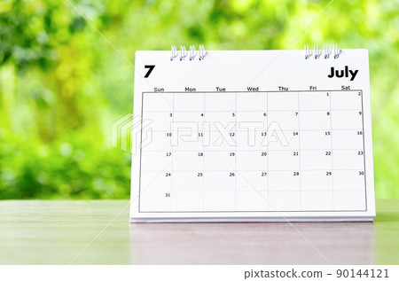 July 2022 Calendar desk for organizer to plan and reminder on wooden table on nature background. July 2022 Calendar desk for organizer to plan and reminder on wooden table on nature background. 90144121