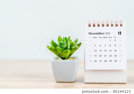 December 2022 desk calendar on wooden background. 90144123