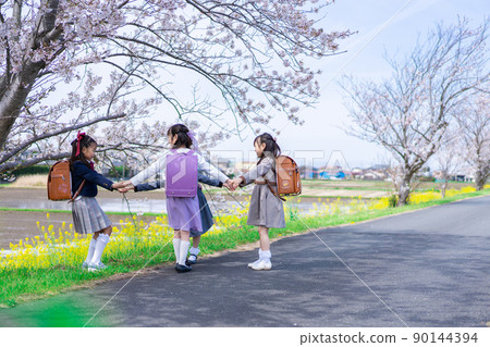 上學和放學時在上學路上玩耍的小學女生 90144394