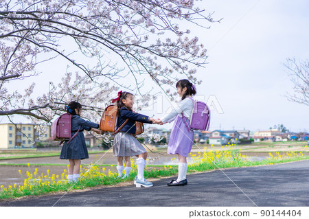 Elementary school girls playing on the way to school while going to and from school 90144404