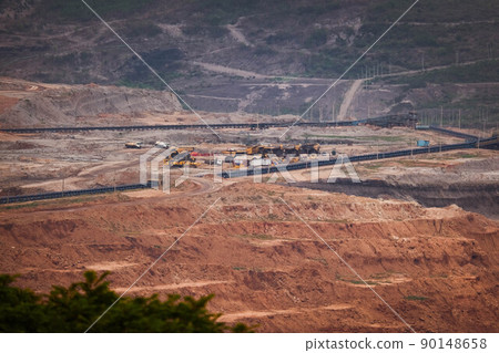 View of Trucks and excavators work in open pits in lignite coal mines. Lignite Coal Extraction Industry. The famous outdoor learning center of Mae Moh Mine Park, Lampang, Thailand. View of Trucks and excavators work in open pits in lignite coal mines. Lignite Coal Extraction Industry. The famous outdoor learning center of Mae Moh Mine Park, Lampang, Thailand. 90148658