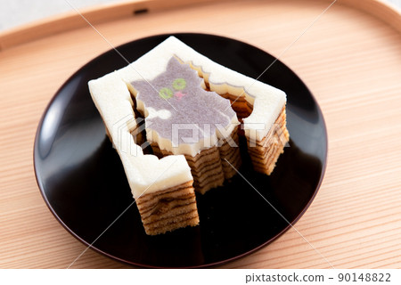 Die-cut Baumkuchen cat on a wooden tray and a black plate Die-cut Baumkuchen cat on a wooden tray and a black plate 90148822