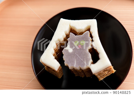 Die-cut Baumkuchen cat on a wooden tray and a black plate Die-cut Baumkuchen cat on a wooden tray and a black plate 90148825