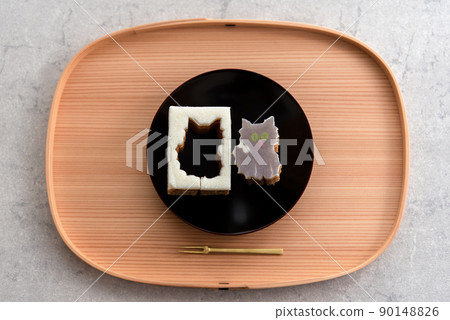 Die-cut Baumkuchen cat on a wooden tray and a black plate Die-cut Baumkuchen cat on a wooden tray and a black plate 90148826