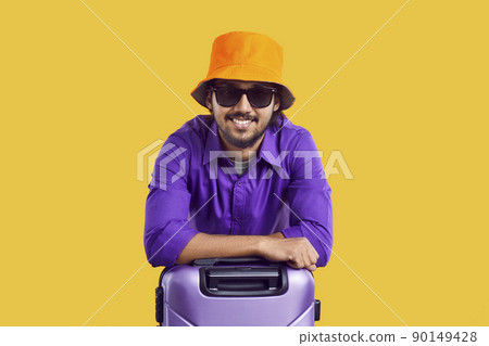 Portrait of happy tourist in summer hat and sunglasses leaning on suitcase and smiling Portrait of happy tourist in summer hat and sunglasses leaning on suitcase and smiling 90149428