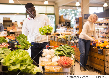 Man buying vegetables in supermarket 90149942