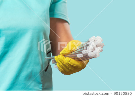 Dentist's hand in glove with saliva ejectors. Dentist's hand in glove with saliva ejectors. 90150880