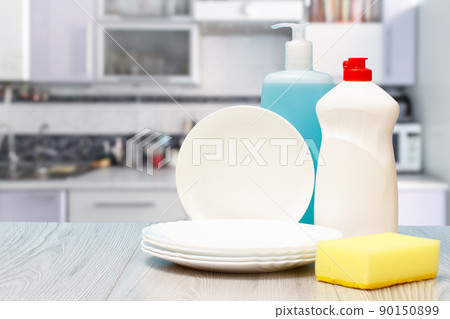 Bottles of dishwashing liquid, plates and sponge. Bottles of dishwashing liquid, plates and sponge. 90150899