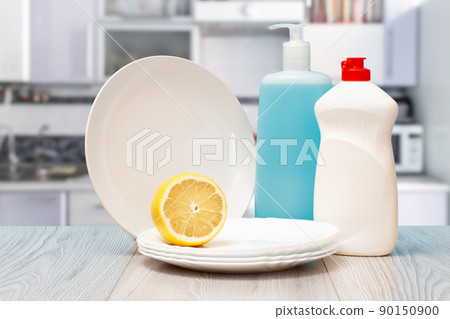 Bottles of dishwashing liquid, plates and lemon. Bottles of dishwashing liquid, plates and lemon. 90150900