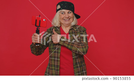 Woman blogger take selfie on mobile phone selfie stick communicate video call online with subscriber Woman blogger take selfie on mobile phone selfie stick communicate video call online with subscriber 90153855