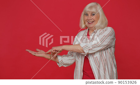 Senior woman pointing empty place advertising area for commercial text copy space, goods promotion Senior woman pointing empty place advertising area for commercial text copy space, goods promotion 90153926