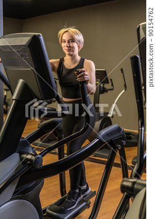 Elliptical trainer young woman machine, In the afternoon female exercise from adult instructor classes, room one. Enter cycle muscle, fitness 90154762