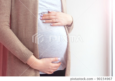 Pregnant woman by the window. Close up. Pregnant woman by the window. Close up. 90154967