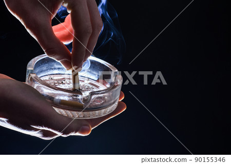 Trash the ash. Cigarette smoking. Hand stubbing out cigarette on ashtray. Quit smoking, copy space 90155346
