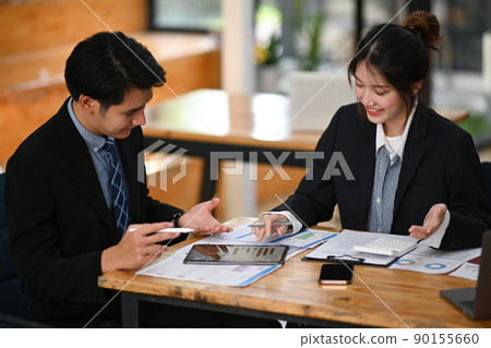 Shot of young businessman explaining financial data on digital tablet to his business partner Shot of young businessman explaining financial data on digital tablet to his business partner 90155660
