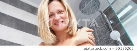A nude beautiful woman smiles in the shower A nude beautiful woman smiles in the shower 90156205