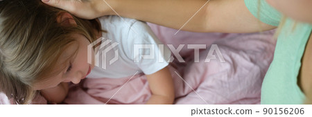 Little girl is sad on the bed, next to mom Little girl is sad on the bed, next to mom 90156206