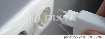 Hand inserts laptop power supply into the socket Hand inserts laptop power supply into the socket 90156281