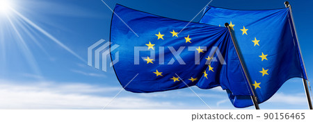 Two European Union Flags Blowing in the Wind on Blue Sky with Clouds 90156465