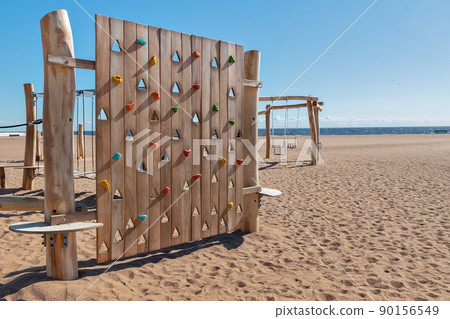 children's natural wooden playground climbing wall on beach by sea on sunny day children's natural wooden playground climbing wall on beach by sea on sunny day 90156549