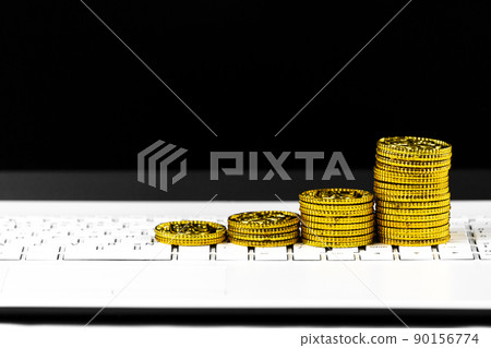 Stacked gold coins and laptops, business image Stacked gold coins and laptops, business image 90156774