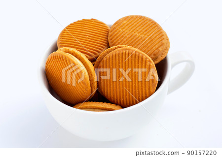 Custard cream sandwich biscuits in cup on white background. Custard cream sandwich biscuits in cup on white background. 90157220