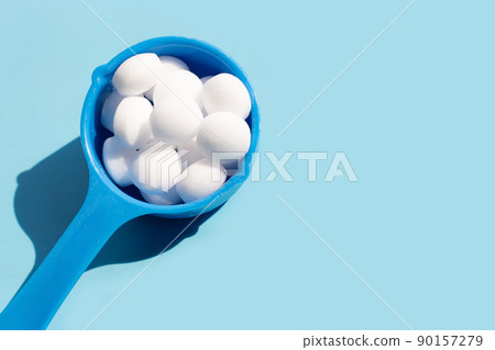 Naphthalene mothballs on blue backgrond. 90157279