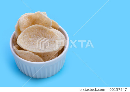 Prawn crackers on blue background. Shrimp crispy rice snack Prawn crackers on blue background. Shrimp crispy rice snack 90157347
