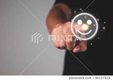 Evaluation and satisfaction concept. Index Finger of hand points to smile emotion. Close up shot on grey background. 90157828