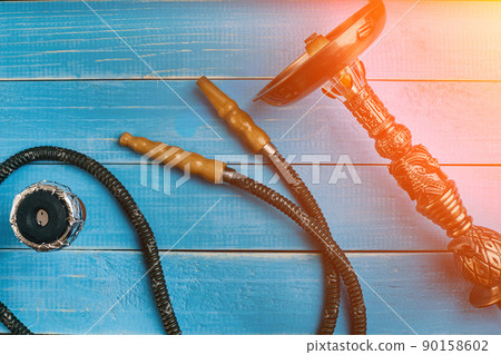 Parts of the hookah on blue wooden background. Hookah accessorie Parts of the hookah on blue wooden background. Hookah accessorie 90158602