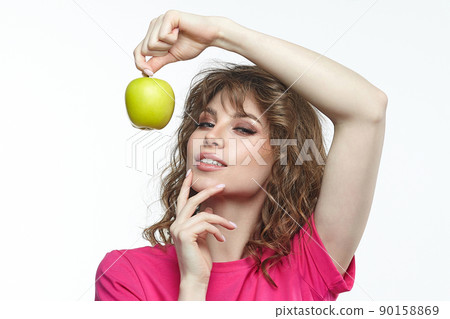 attractive girl seductively holds a ripe green apple in her hands. attractive girl seductively holds a ripe green apple in her hands. 90158869