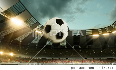 Flight of soccer football ball through crowded stadium with spotlights in evening time. Concept of sport, art, energy, power. Unfocus effect Flight of soccer football ball through crowded stadium with spotlights in evening time. Concept of sport, art, energy, power. Unfocus effect 90159343
